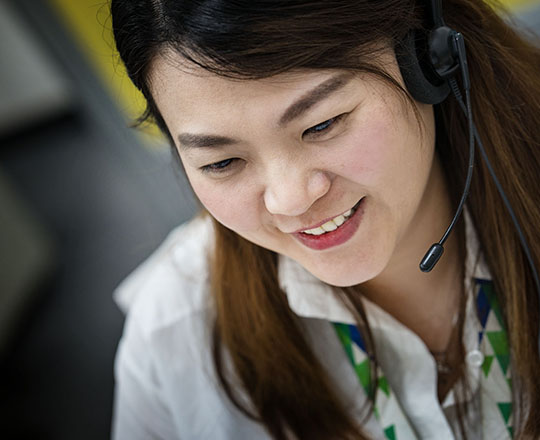 Asian woman dispatcher with headset, close-up